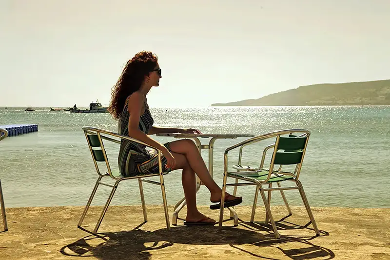 آرامش دختر مو فر قهوه ای با پیرهن کوتاه دخترانه در کنار ساحل ازمیر